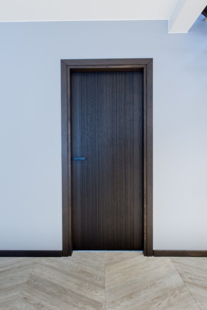 Podłogi drewniane: T-1010 Amiata. Drzwi z litego drewna, kolor 3479 Antique, model Velvet.