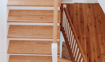 Przestrzeń emanująca spokojem: Drewniane drzwi dopasowane do dębowych podłóg i schodów