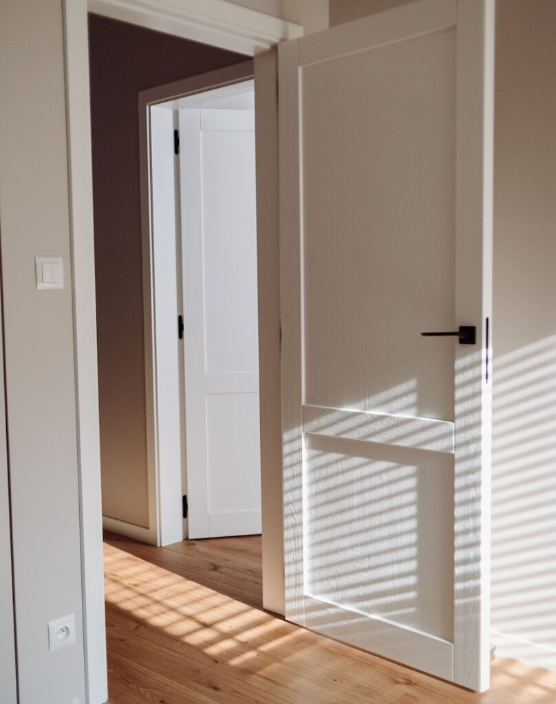 Przestrzeń emanująca spokojem: Drewniane drzwi dopasowane do dębowych podłóg i schodów